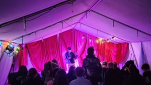 Publikum in einem Zelt mit lila Beleuchtung
